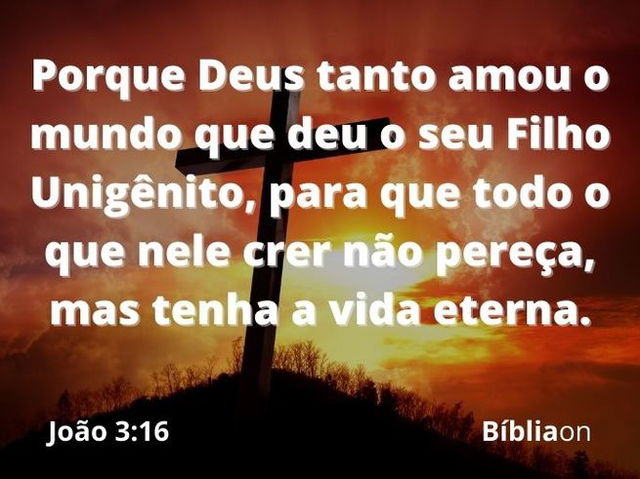 Uma cruz cravada em um monte, com um pôr do sol avermelhado atrás. Versículo é João três dezesseis, que diz: Porque Deus tanto amou o mundo que deu o seu Filho Unigênito, para que todo o que nele crer não pereça, mas tenha a vida eterna.